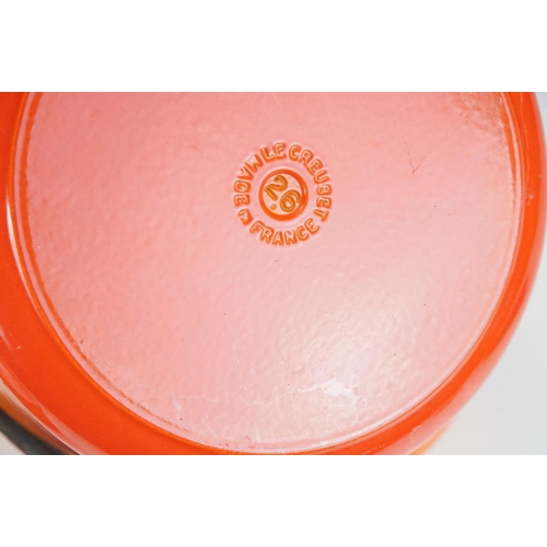 127 - Three Le Creuset lidded orange pans in graduating sizes, two round, 18 & 26 and one oval example BC,... 