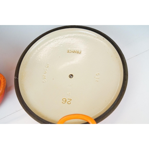 127 - Three Le Creuset lidded orange pans in graduating sizes, two round, 18 & 26 and one oval example BC,... 