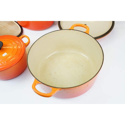 127 - Three Le Creuset lidded orange pans in graduating sizes, two round, 18 & 26 and one oval example BC,... 