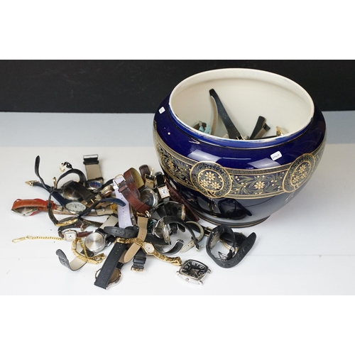 302 - A large collection of mixed wristwatches contained within a large porcelain bowl.