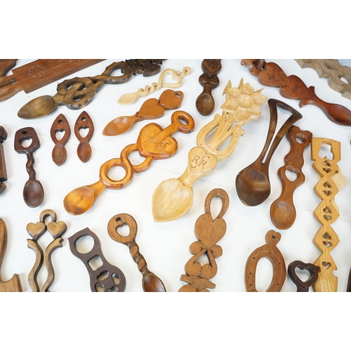 389 - A large collection of wooden Welsh love spoons of various sizes, mainly contemporary examples.