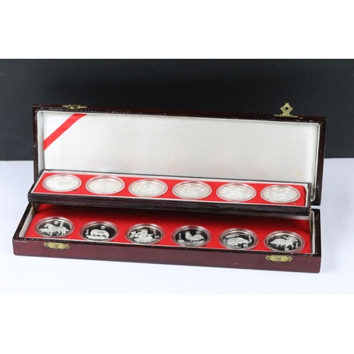 148 - A collection of twelve Chinese new year collectors coins encapsulated and contained within a two tie... 