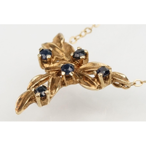 128 - Two 9ct gold fine link necklace chains to include a 9ct gold and sapphire pendant on a rolled gold f... 