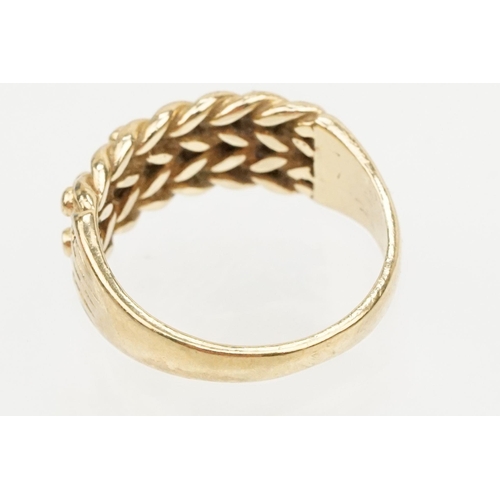 152 - 9ct gold keepers ring with knotted design head. Hallmarked Sheffield 1989. Size L.5.