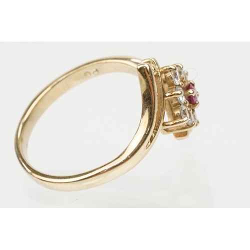 159 - 9ct gold cubic zirconia and ruby crossover ring having a round cut ruby to entre surrounded by round... 