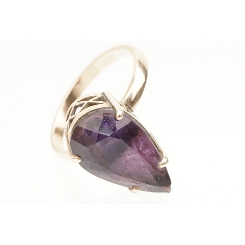 162 - Amethyst and yellow metal ring. The ring being set with a pear cut amethyst set within a basket sett... 