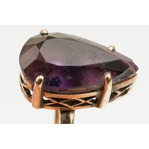 162 - Amethyst and yellow metal ring. The ring being set with a pear cut amethyst set within a basket sett... 