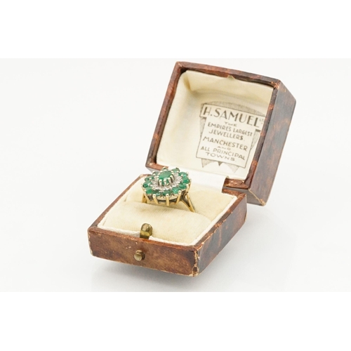 21 - 9ct gold, emerald and diamond cluster ring. The ring being set with a central oval cut emerald surro... 