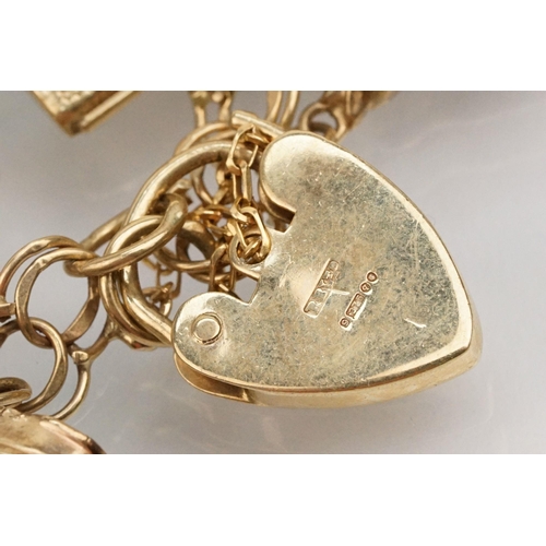 215 - 9ct gold double link bracelet with heart padlock clasp, having 21 charms. 19 charms marked 9ct or ha... 