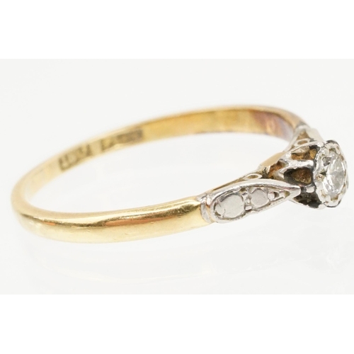 218 - 18ct gold and diamond ring being set with a round brilliant cut diamond on platinum shoulders. Band ... 