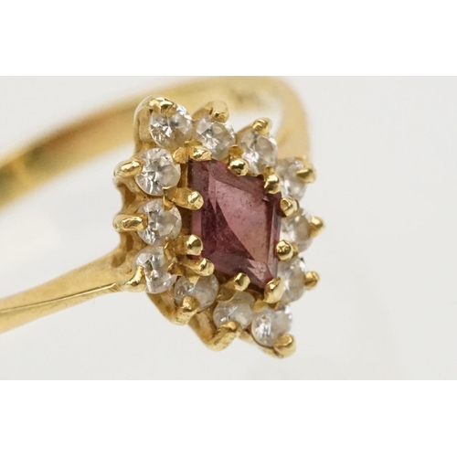 223 - 18ct gold ruby and cz ring. The ring being set with a step cut ruby with a halo of round cut cz's. B... 