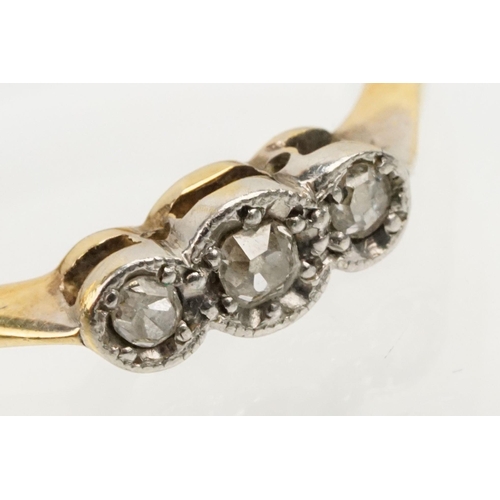 235 - 18ct gold and platinum three stone ring. The ring being illusion set with three round cut diamonds (... 