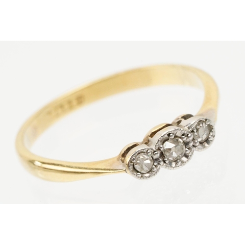 235 - 18ct gold and platinum three stone ring. The ring being illusion set with three round cut diamonds (... 