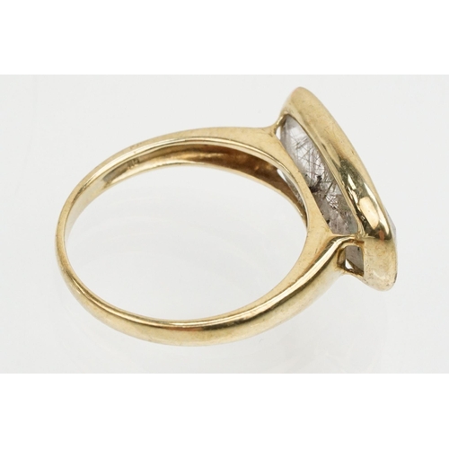 240 - 9ct gold and rutilated quartz ring. The ring being bezel set with a mixed cut rectangular stone on a... 