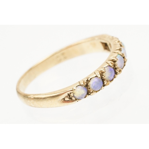 243 - Opal seven stone ring set with seven round opal cabochons. Marks rubbed, tests indicate 9ct gold. Si... 