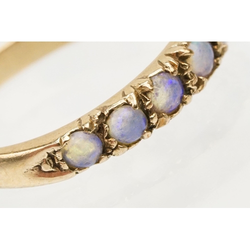 243 - Opal seven stone ring set with seven round opal cabochons. Marks rubbed, tests indicate 9ct gold. Si... 