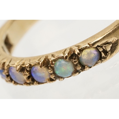 243 - Opal seven stone ring set with seven round opal cabochons. Marks rubbed, tests indicate 9ct gold. Si... 