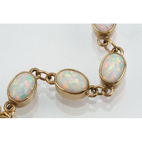 28 - 9ct gold and synthetic opal line bracelet. The bracelet bezel set with oval cabochons. Marked 375 to... 