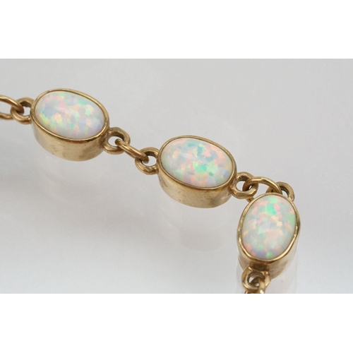 28 - 9ct gold and synthetic opal line bracelet. The bracelet bezel set with oval cabochons. Marked 375 to... 