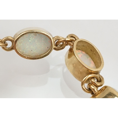 28 - 9ct gold and synthetic opal line bracelet. The bracelet bezel set with oval cabochons. Marked 375 to... 