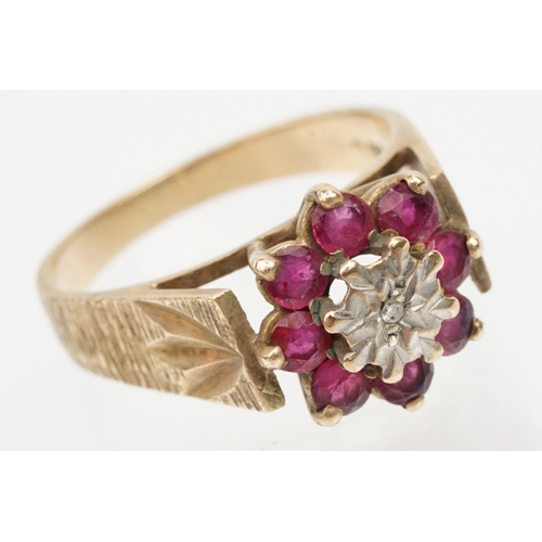 96 - 9ct gold ruby and diamond cluster ring. The ring being illusion set with a round cut diamond to cent... 