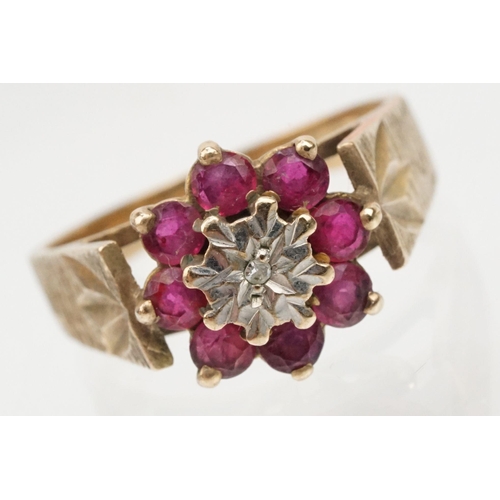 96 - 9ct gold ruby and diamond cluster ring. The ring being illusion set with a round cut diamond to cent... 