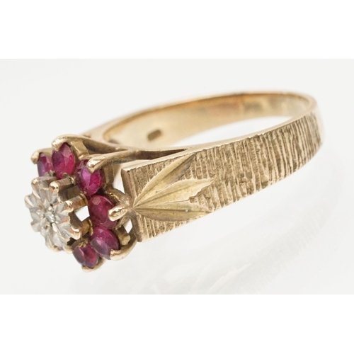 96 - 9ct gold ruby and diamond cluster ring. The ring being illusion set with a round cut diamond to cent... 