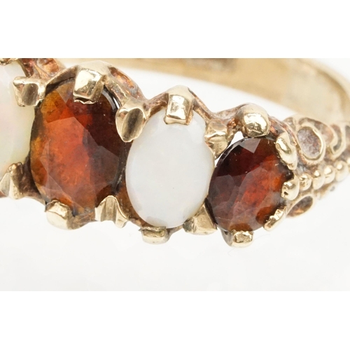 97 - 9ct gold garnet topped doublet and opal five stone ring. The ring being set with three oval cut GTD'... 