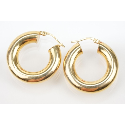 107 - Two pairs of 9ct gold hoop earrings to include a pair of oval hoops with hinged posts (marked 375) a... 