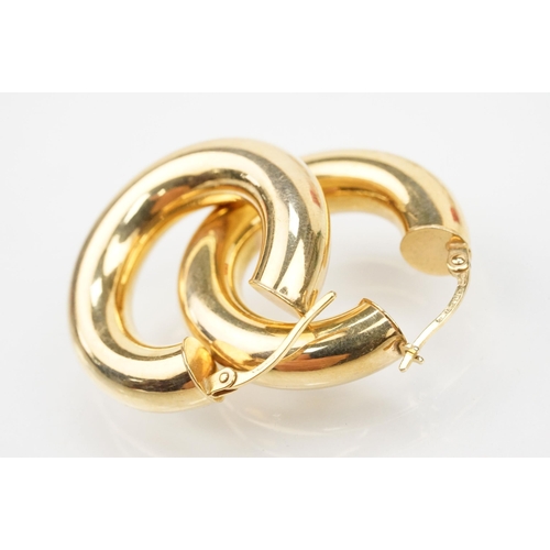 107 - Two pairs of 9ct gold hoop earrings to include a pair of oval hoops with hinged posts (marked 375) a... 