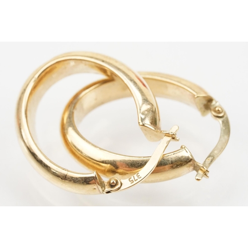 107 - Two pairs of 9ct gold hoop earrings to include a pair of oval hoops with hinged posts (marked 375) a... 