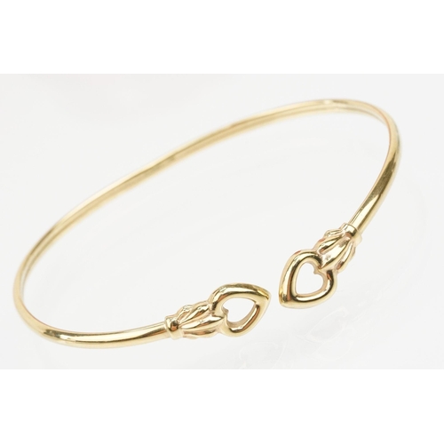 115 - Group of three bracelets to include a 9ct gold open bangle with heart shaped terminals (hallmarked S... 