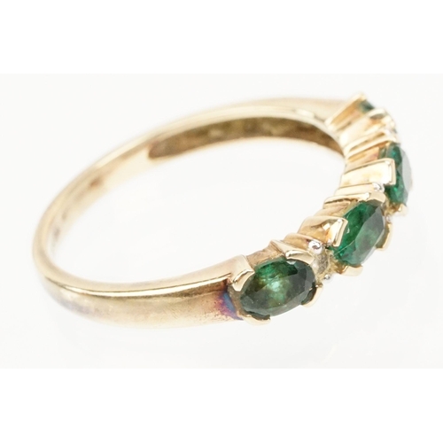 119 - 9ct gold synthetic emerald and diamond line ring. The ring being set with oval cut emeralds with dia... 