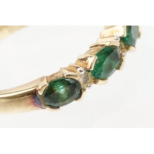 119 - 9ct gold synthetic emerald and diamond line ring. The ring being set with oval cut emeralds with dia... 