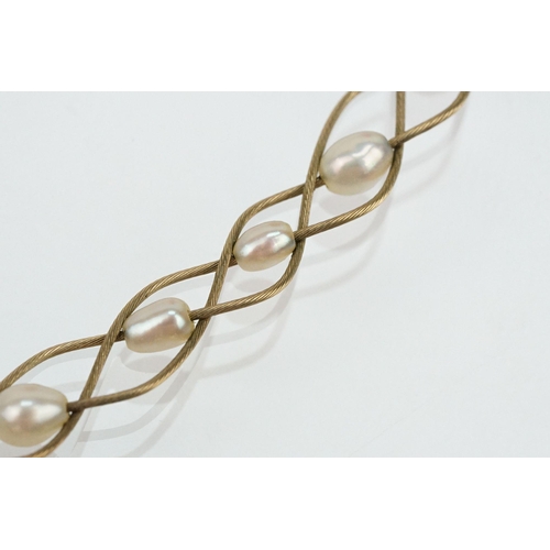 123 - 9ct gold and cultured pearl necklace having three woven chains threaded with cultured pearls and a l... 