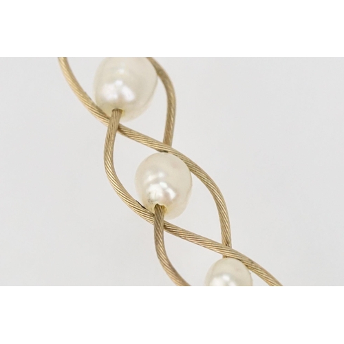 123 - 9ct gold and cultured pearl necklace having three woven chains threaded with cultured pearls and a l... 