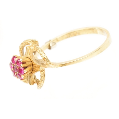 185 - 18ct gold and ruby cluster ring having a cluster of round cut rubies to centre with a pierced floral... 