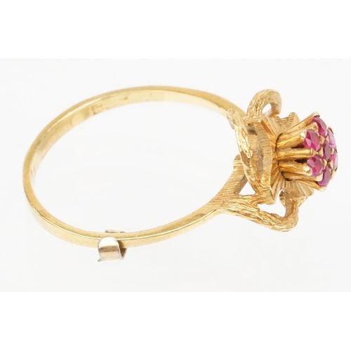 185 - 18ct gold and ruby cluster ring having a cluster of round cut rubies to centre with a pierced floral... 