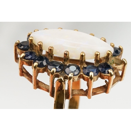 187 - 9ct gold opal and sapphire cluster ring. The ring being set with a marquise opal cabochon to centre ... 