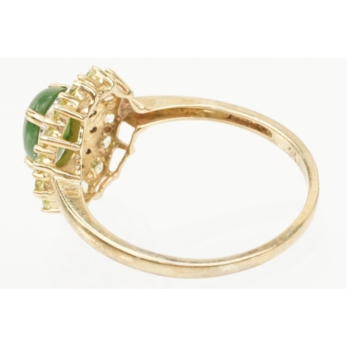 200 - 9ct gold jade and diamond cluster ring. The ring being set with an oval jade cabochon to centre with... 