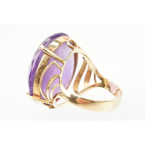 35 - 14ct gold and amethyst dress ring. The ring being set with a large oval cut amethyst in a basket hea... 