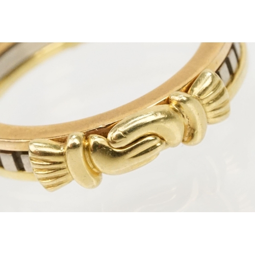 36 - 18ct gold tri tone ring constructed from three interlocking rings with clasped hands to the head, op... 