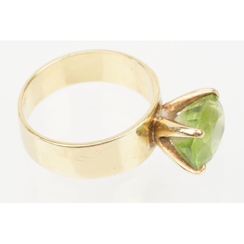 41 - 18ct gold and peridot dress ring. The ring being set with an oval cut peridot in a four prong settin... 