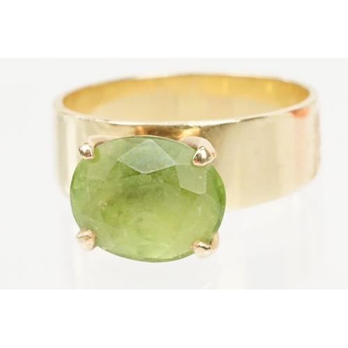 41 - 18ct gold and peridot dress ring. The ring being set with an oval cut peridot in a four prong settin... 