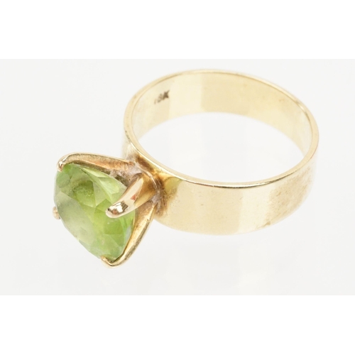 41 - 18ct gold and peridot dress ring. The ring being set with an oval cut peridot in a four prong settin... 