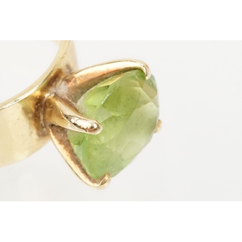 41 - 18ct gold and peridot dress ring. The ring being set with an oval cut peridot in a four prong settin... 