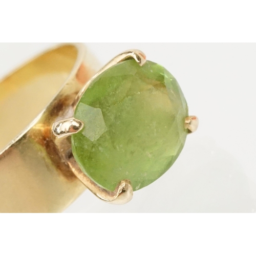 41 - 18ct gold and peridot dress ring. The ring being set with an oval cut peridot in a four prong settin... 