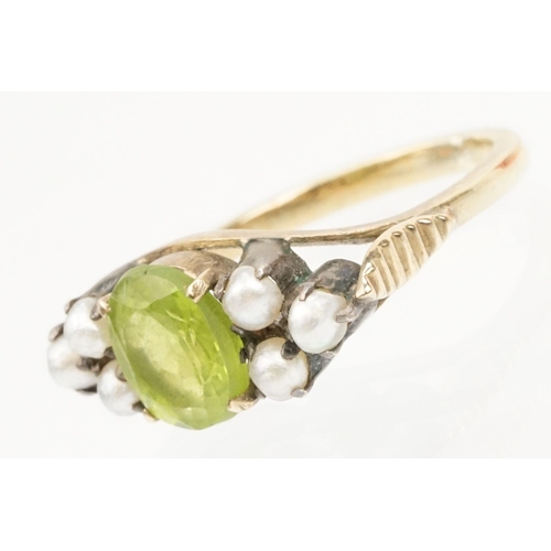 52 - Peridot and pearl dress ring. The ring being set with an oval cut peridot to centre flanked by six s... 