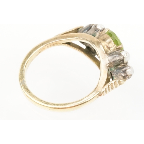 52 - Peridot and pearl dress ring. The ring being set with an oval cut peridot to centre flanked by six s... 