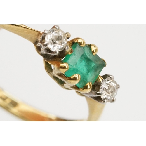 64 - 18ct gold diamond and emerald three stone ring. The ring being set with a square step cut emerald fl... 